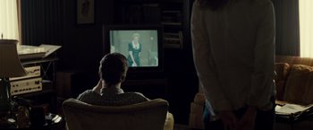 Movie still from “August: Osage County” (2013), directed by John Wells – A person sitting in front of a television; Medium shot, Over the shoulder angle