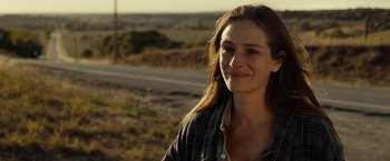 Movie still from “August: Osage County” (2013), directed by John Wells – A woman standing on the side of a road near a field; Close Up shot, Over the shoulder angle