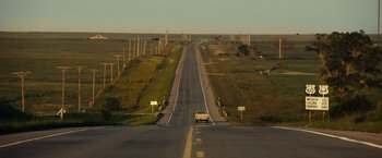 Movie still from “August: Osage County” (2013), directed by John Wells – A car driving down the middle of a road; Extreme Wide shot, High angle