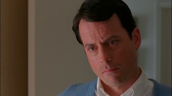 Movie still from “Auto Focus” (2002), directed by Paul Schrader – A person wearing a white shirt and a blue sweater; Close Up shot, Over the shoulder angle