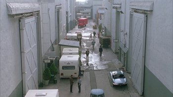 Movie still from “Auto Focus” (2002), directed by Paul Schrader – People are walking down a street in a city; Extreme Wide shot, High angle