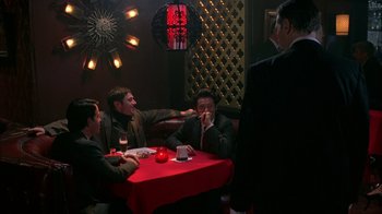 Movie still from “Auto Focus” (2002), directed by Paul Schrader – A group of men sitting at a table in a restaurant; Wide shot, High angle