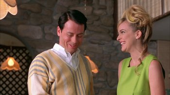 Movie still from “Auto Focus” (2002), directed by Paul Schrader – A man and a woman smiling at each other; Medium shot, Over the shoulder angle