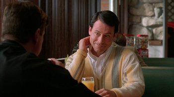 Movie still from “Auto Focus” (2002), directed by Paul Schrader – A man sitting at a table with a glass of beer; Close Up shot, Over the shoulder angle
