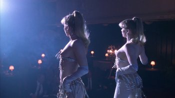 Movie still from “Auto Focus” (2002), directed by Paul Schrader – A couple of women are dancing in a room; Medium shot, Low angle