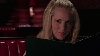 Movie still from “Auto Focus” (2002), directed by Paul Schrader – A woman is holding a black folder in her hands; Close Up shot, Over the shoulder angle