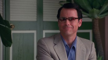 Movie still from “Auto Focus” (2002), directed by Paul Schrader – A person wearing glasses and a suit; Close Up shot, Over the shoulder angle