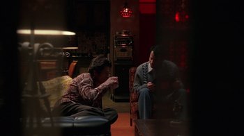Movie still from “Auto Focus” (2002), directed by Paul Schrader – Two people are sitting in a living room drinking coffee; Wide shot, Over the shoulder angle