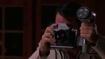 Movie still from “Auto Focus” (2002), directed by Paul Schrader – A person taking a picture with an old camera; Close Up shot, Low angle