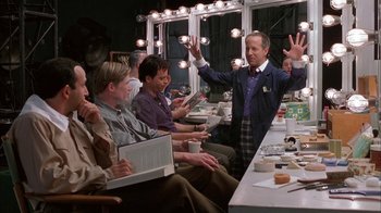 Movie still from “Auto Focus” (2002), directed by Paul Schrader – A group of people sitting around a table; Medium shot, Over the shoulder angle