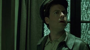 Movie still from “Auto Focus” (2002), directed by Paul Schrader – A man wearing a hat looking up at the sky; Close Up shot, Low angle