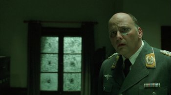 Movie still from “Auto Focus” (2002), directed by Paul Schrader – A man in a military uniform standing in front of a window; Close Up shot, Over the shoulder angle
