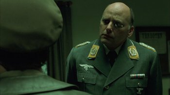 Movie still from “Auto Focus” (2002), directed by Paul Schrader – A man in a uniform looking at himself in a mirror; Close Up shot, Over the shoulder angle
