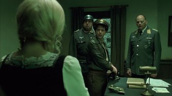 Movie still from “Auto Focus” (2002), directed by Paul Schrader – A group of men standing next to each other in a room; Medium shot, Over the shoulder angle