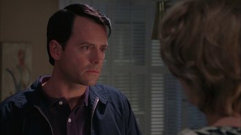 Movie still from “Auto Focus” (2002), directed by Paul Schrader – A man in a purple shirt is looking at a woman in a blue jacket; Close Up shot, Over the shoulder angle