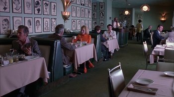 Movie still from “Auto Focus” (2002), directed by Paul Schrader – A group of diners sitting at a booth in a restaurant; Wide shot, Over the shoulder angle