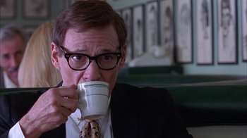 Movie still from “Auto Focus” (2002), directed by Paul Schrader – A man in a suit and tie drinking a cup of coffee; Close Up shot, Over the shoulder angle