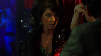Movie still from “Auto Focus” (2002), directed by Paul Schrader – A woman sitting at a table with a glass of wine; Close Up shot, Over the shoulder angle