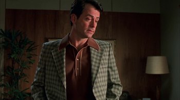 Movie still from “Auto Focus” (2002), directed by Paul Schrader – A man wearing a suit and a brown shirt; Close Up shot, Low angle