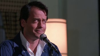 Movie still from “Auto Focus” (2002), directed by Paul Schrader – A man standing up with a microphone in front of him; Close Up shot, Low angle