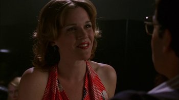 Movie still from “Auto Focus” (2002), directed by Paul Schrader – A woman in a red polka dot dress smiling; Close Up shot, Over the shoulder angle