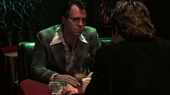 Movie still from “Auto Focus” (2002), directed by Paul Schrader – A man sitting at a table in front of another man; Medium shot, Over the shoulder angle