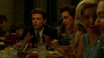 Movie still from “Avalon” (1990), directed by Barry Levinson – A group of people sitting at a dinner table; Medium shot, Over the shoulder angle
