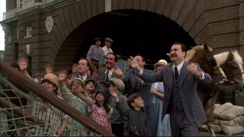 Movie still from “Avalon” (1990), directed by Barry Levinson – A group of people standing in front of an archway; Wide shot, Low angle