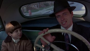 Movie still from “Avalon” (1990), directed by Barry Levinson – A man in a hat and a woman in a hat in the back of a car; Close Up shot, Over the shoulder angle