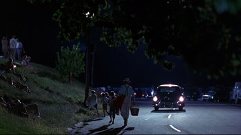 Movie still from “Avalon” (1990), directed by Barry Levinson – A group of people walking down a street at night; Extreme Wide shot, Low angle