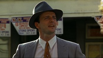 Movie still from “Avalon” (1990), directed by Barry Levinson – A man wearing a suit and a hat is standing outside; Close Up shot, Low angle