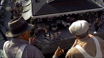 Movie still from “Avalon” (1990), directed by Barry Levinson – A group of people standing on top of a street; Wide shot, Overhead angle