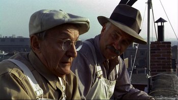 Movie still from “Avalon” (1990), directed by Barry Levinson – Two older men wearing hats and overalls; Close Up shot, Low angle