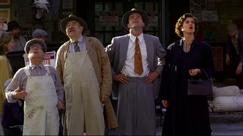 Movie still from “Avalon” (1990), directed by Barry Levinson – A group of people standing next to each other on a street; Wide shot, Low angle