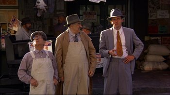Movie still from “Avalon” (1990), directed by Barry Levinson – A group of people standing next to each other wearing hats; Wide shot, High angle
