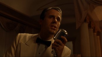 Movie still from “Avalon” (1990), directed by Barry Levinson – A man holding a microphone in his hand; Close Up shot, Low angle