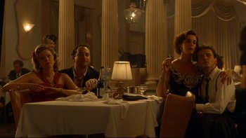 Movie still from “Avalon” (1990), directed by Barry Levinson – A group of people sitting at a table in front of a lamp; Medium shot, Low angle