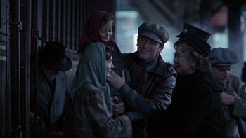 Movie still from “Avalon” (1990), directed by Barry Levinson – A group of people standing next to each other on a street; Medium shot, Over the shoulder angle