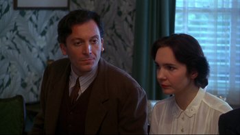 Movie still from “Avalon” (1990), directed by Barry Levinson – A man and a woman sitting next to each other; Close Up shot, Over the shoulder angle