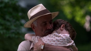 Movie still from “Avalon” (1990), directed by Barry Levinson – An older man holding a young child in his arms; Close Up shot, Low angle