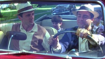 Movie still from “Avalon” (1990), directed by Barry Levinson – Two men and a child in a car; Medium shot, Over the shoulder angle