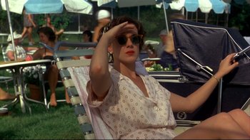 Movie still from “Avalon” (1990), directed by Barry Levinson – A woman sitting on a lawn chair in a park; Medium shot, High angle