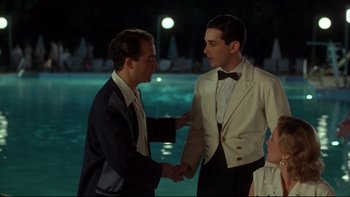 Movie still from “Avalon” (1990), directed by Barry Levinson – Two young men shaking hands in front of a pool; Medium shot, Over the shoulder angle