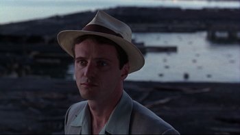 Movie still from “Avalon” (1990), directed by Barry Levinson – A man wearing a hat standing in front of a body of water; Close Up shot, Over the shoulder angle