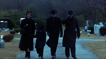 Movie still from “Avalon” (1990), directed by Barry Levinson – A group of people walking down a street at night; Wide shot, Low angle