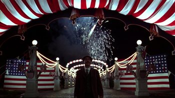Movie still from “Avalon” (1990), directed by Barry Levinson – A man standing in front of fireworks at night; Wide shot, Low angle