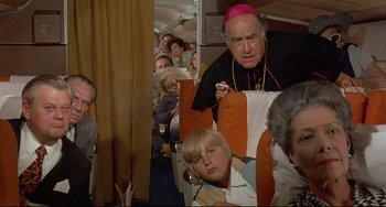 Movie still from “Avanti!” (1972), directed by Billy Wilder – An older man and a young boy sitting on a plane; Medium shot, High angle