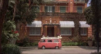 Movie still from “Avanti!” (1972), directed by Billy Wilder – A pink van parked in front of a building; Wide shot, Low angle