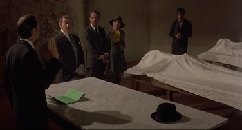 Movie still from “Avanti!” (1972), directed by Billy Wilder – A group of people standing in front of a table; Wide shot, High angle