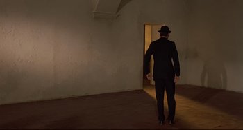 Movie still from “Avanti!” (1972), directed by Billy Wilder – A man in a suit and a hat walking in a room; Wide shot, Low angle
